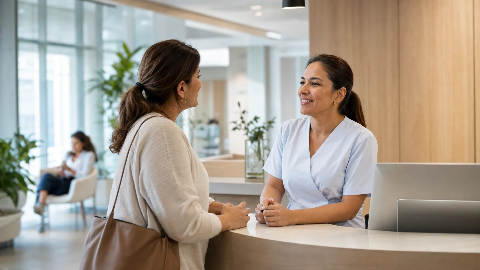 Recepción de una clínica moderna: una paciente conversa con una funcionaria